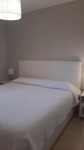 洛思坎加约斯Los Cancajos Apartamento Acijoa的白色卧室内的一张白色床,配有灯
