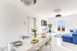 马萨鲁布朗斯Villa Rusinella的白色的客厅配有桌子和蓝色的沙发
