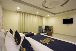 新德里Hotel Grand Suites By D Capitol- New Delhi Airport的酒店客房设有两张床和一台平面电视。
