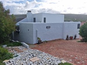 阿古拉斯South Of Africa的前面有一条石头路的白色房子