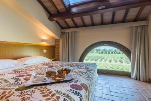 圣阿尔坎杰洛-迪罗马涅Collina dei Poeti的一间酒店客房,配有一张床铺,上面放着一个食物托盘