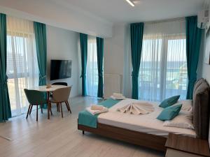 马马亚North Club Apartments II的一间卧室配有一张大床和一张桌椅