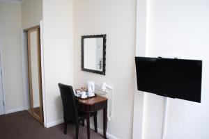曼彻斯特曼彻斯特市中心大不列颠酒店的客房设有书桌、电视和椅子