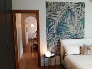 阿罗纳Suite 51 Appartamento con terrazzo a 50 mt dal lago - Private Parking的一间卧室配有一张床和壁画墙