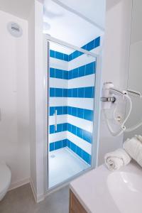 土伦Apparthotel Le Hüb TOULON的一间设有蓝色和白色条纹淋浴的浴室