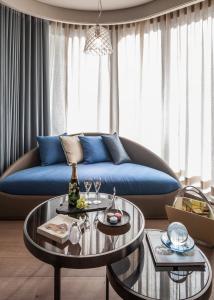 北京北京三里屯通盈中心洲际酒店的客厅配有蓝色的沙发和2张桌子