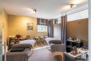 马斯梅赫伦Maas&Mechelen B&B Massage & Wellness的配有四张床和一张桌子的理疗室