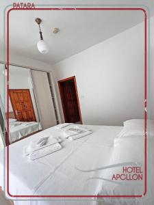 帕塔拉阿波罗大酒店 的一张白色的床,位于带镜子的房间里
