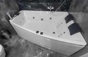 基辅Luxury Apartments Arena Guliver的带白色浴缸的浴室和卫生间
