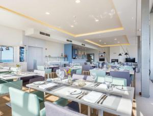拉戈斯Palmares Signature Apartments的用餐室配有白色的桌子和蓝色的椅子