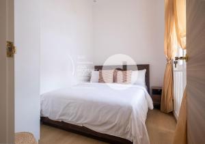 新加坡hovoh homes Bugis Rochor的一间卧室配有带白色床单和枕头的床。