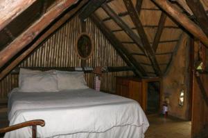 摩根湾Yellowwood Forest Eco Retreat的阁楼上的卧室配有一张大床