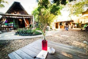 摩根湾Yellowwood Forest Eco Retreat的坐在院子木桌旁的红色花瓶