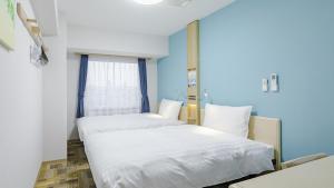 大阪Toyoko Inn Osaka Bentencho的蓝色墙壁客房的两张床