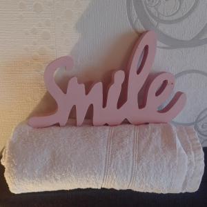 滨湖克拉科Zimmer und Apartment Rosi的白色毛巾上微笑的粉红色标志