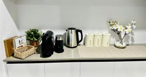 帕金顿Spacious modern family home的一个带咖啡壶和鲜花的柜台