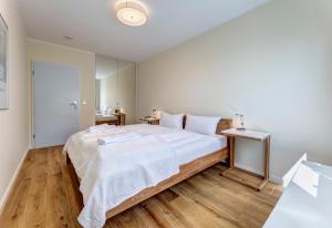 黑灵斯多夫Villa Madeleine App. 2的一间卧室设有一张大床,铺有木地板