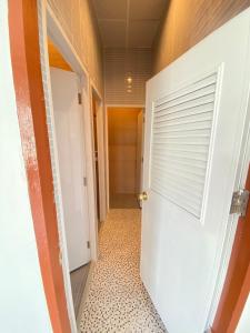 坤敬Baan Hall Hostel的走廊设有白色门和瓷砖地板