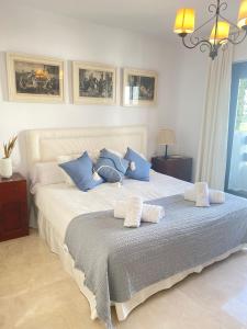马贝拉Homey Home Guadalvillas 91的一间卧室配有一张带蓝白色枕头的大床