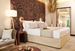 珀蒂蒂勒Palm Hotel & Spa的酒店客房带一张大床和一把椅子