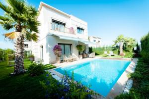 阿加迪尔Villa Palmeraie Golf Agadir的别墅前设有游泳池
