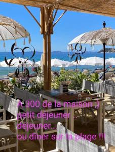 拉克鲁瓦瓦尔梅Le demeure de Poulpican chambre LA GROTTE jacuzzi charme romantique terrasse privée 300m plage et restaurants La Croix Valmer - Golfe Saint Tropez的海滩上设有椅子和遮阳伞,还有大海