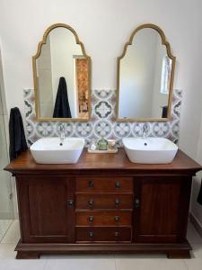 德班Stirling Cottage的浴室设有2个盥洗盆和2面镜子,位于梳妆台上