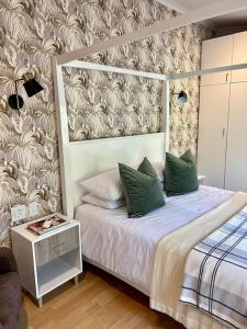 德班Stirling Cottage的一间卧室配有一张带绿色枕头的床