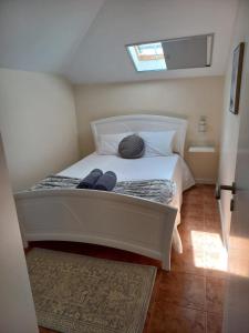 阿科达卡列塔Casa Dos Ramos的一间小卧室,配有一张白色的床和窗户