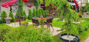 普洛耶什蒂Hotel Yarus Plus的花园内带桌椅的庭院