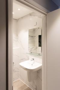 伦敦王子广场旅馆的白色的浴室设有水槽和镜子