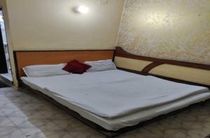 新德里OYO Hotel Travel INN的一张铺有白色床单的床,上面有红色的物品