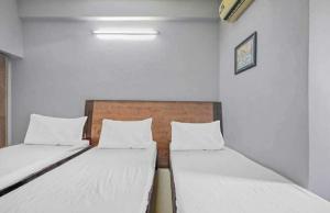 新德里OYO Hotel Travel INN的配有白色墙壁的小客房内的两张床