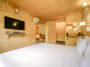 斯利那加幻影酒店的一间卧室配有一张床,墙上配有电视