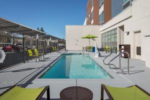 西萨克拉门托SpringHill Suites by Marriott West Sacramento的大楼内一个带桌椅的游泳池