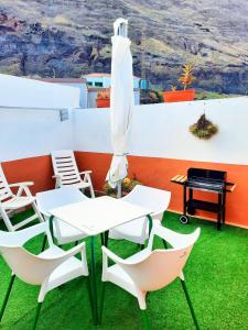 弗龙特拉Vivienda vacacional Casa Rosi的庭院里配有桌椅和遮阳伞