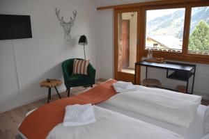迪森蒂斯Hotel Pazzola的一间卧室配有一张床、一张书桌和一个窗户。