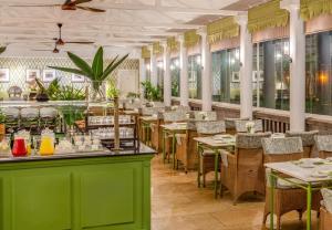 内罗毕费尔蒙诺福克酒店的餐厅设有绿色的柜台和桌椅