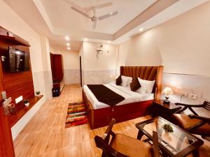 穆索里Doon Nature Valley Resort, Kempty Fall Mussoorie的卧室配有一张床和一张桌子
