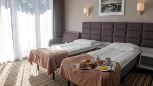 达洛科Waterside Resort的酒店客房设有两张床和一盘食物