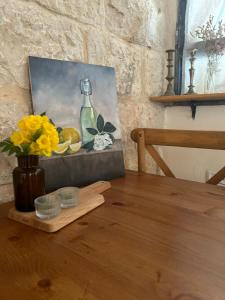 Ilaniyyaצימר חצר שמואלי - יחידת אירוח זוגית במושב אילניה的木桌上一幅画,上面画着一瓶和水果