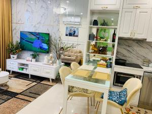 河内Lu Luxury Homestay et Apartment - Vinhomes Smart City Hanoi的一间厨房,内设桌子和一台电视机
