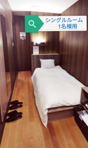 埼玉市Petit Hotel mio的卧室配有床和鞋子,位于地板上