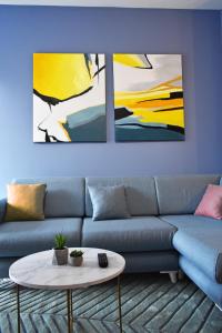 地拉那Vibrant Apartment的客厅配有蓝色沙发和两幅画作