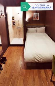 埼玉市Petit Hotel mio的一间卧室配有一张床,浴室设有淋浴。