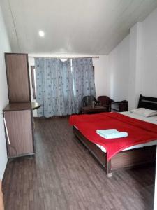 库尔卢SPOT ON Hotel Rudra的一间卧室配有一张带红色毯子的大床