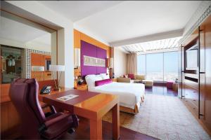 迪拜迪拜H酒店的配有一张床、一张桌子和一张桌子的酒店客房
