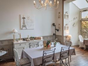 迪南La Villa Côté Cour的厨房以及带桌子和吊灯的用餐室。