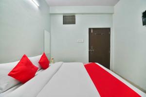 科塔Flagship Hotel Bliss的一间卧室配有一张带红色枕头的床