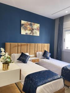 迈尔提勒HOSTAL MH BORJ的蓝色墙壁客房的两张床